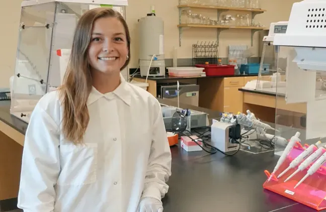 Avery Bond in a whitecoat standing in a lab